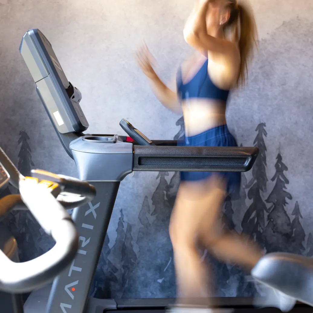 A person is jogging on a treadmill in a gym.